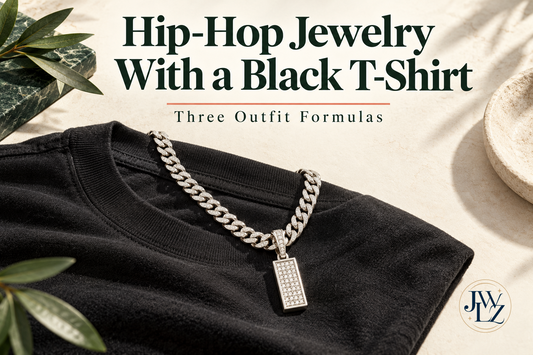 Editorial illustration of a black T-shirt with a silver-tone Cuban chain and rectangular pendant on an ivory styling board