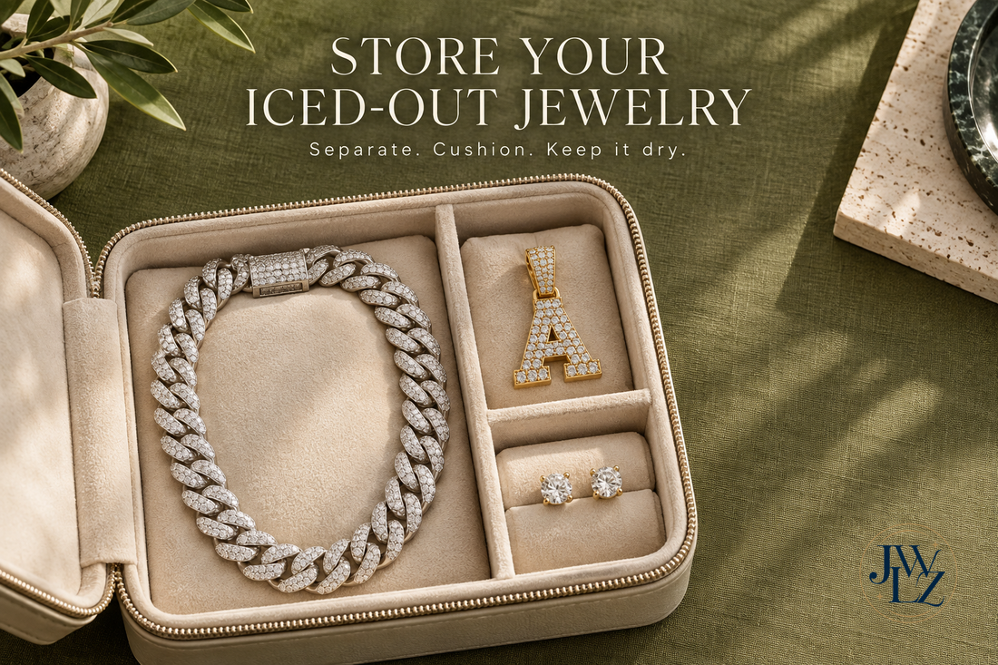 Conceptual iced Cuban chain, letter pendant and stud earrings separated in a cream padded jewelry case on olive fabric.