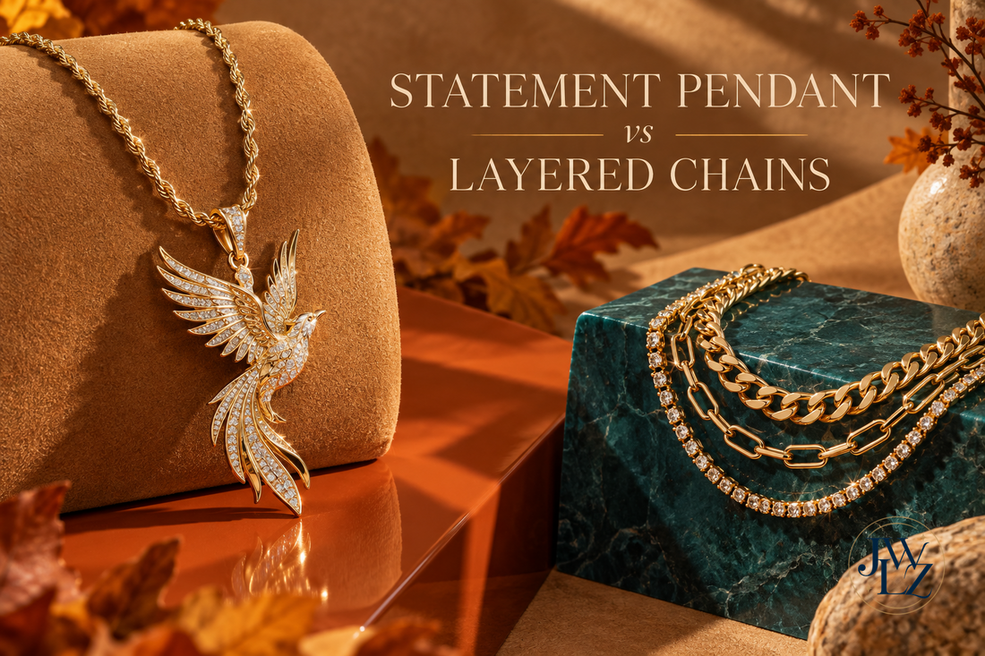 Fall 2026 jewelry styling scene comparing one bird-inspired statement pendant with layered gold-tone chains on camel and teal displays.