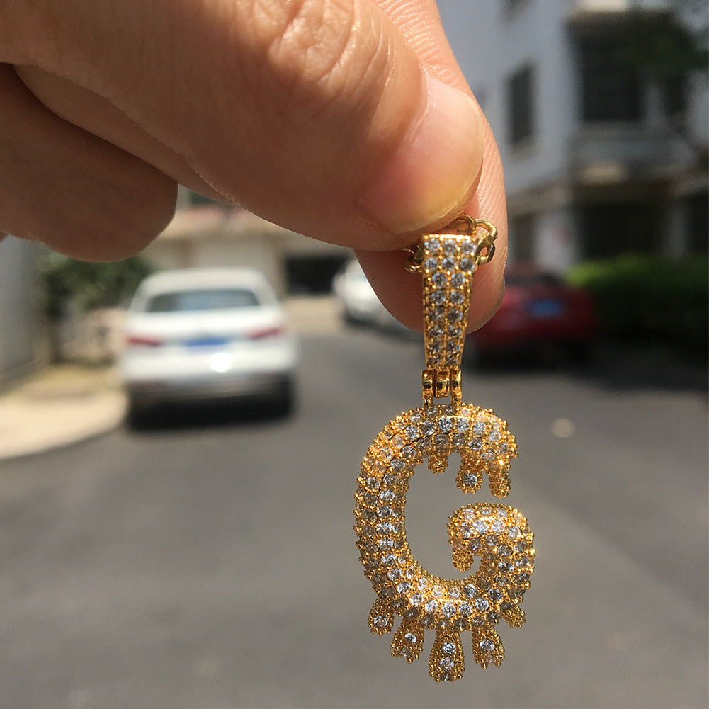 Gold-tone number 8 drop pendant held outdoors product image